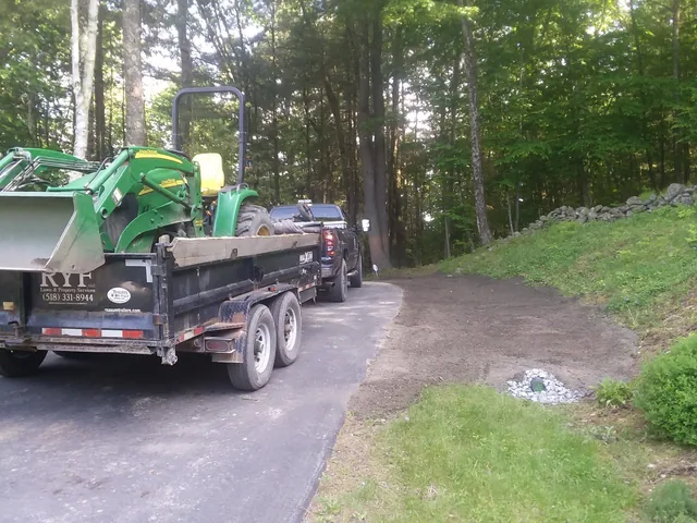 A tractor and dump trailer delivering bulk material on site